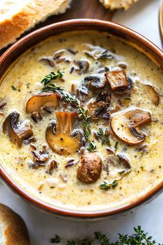 a bowl of mushroom soup with bread on the side