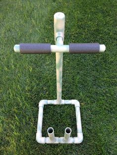 a toilet in the shape of a square with two pipes attached to it on some grass