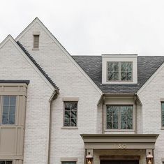 a large white brick house with two story windows