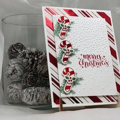 a christmas card with candy canes and pine cones