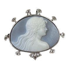 This is one of the most beautiful Antique Art Nouveau - Belle Epoque Hardstone Cameo Brooches we have seen. The extraordinary hand carved image of the woman, or Goddess, is framed by a halo of Rose Cut Diamonds set in Platinum atop 14 Karat Gold. The Art Nouveau cameo artisans created some of the most exquisite hard stone cameos the world has ever seen and this is one of the finest examples. The cameo is carved from a blue and white hard stone that is known as Chalcedony. The gem has a stunning light blue color background that lets just the perfect amount of light through to highlight the white stone of the goddess woman. The carving is the work of a master artisan. The face is a masterpiece of artistic expression, and is carved with exquisite detail throughout, the hair is stunning, and I Light Blue Color Background, Blue Color Background, Bijoux Art Nouveau, Magical Art, Cameo Brooch, Antique Diamond, Gold Art, Light Blue Color, Rose Cut Diamond