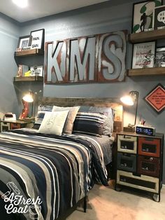 a bedroom decorated in blue and gray with pictures on the wall above the headboard