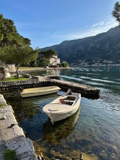 two small boats are docked at the shore