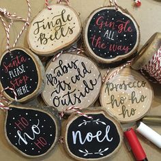 christmas ornaments made from wood slices with handwritten words on them and twine ribbons