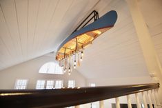 a chandelier hanging from the ceiling in a room with white walls and wood floors