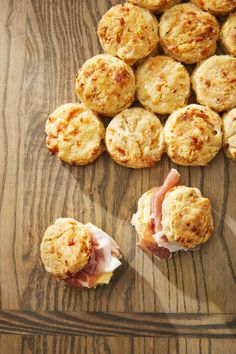 ham and cheese muffins on a wooden cutting board next to other food items