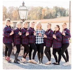 a group of women standing next to each other in front of a light pole and lamp post