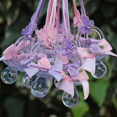 a pink and purple flower hanging from a chandelier with lots of glass beads