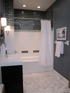 a bathroom with gray walls and white tile on the floor, along with a bathtub