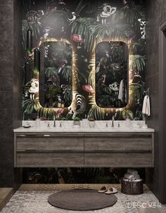 a bathroom with two sinks, mirrors and jungle wallpaper on the walls behind them