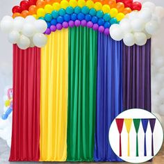 the balloon arch is decorated with multicolored balloons and streamers for a rainbow themed birthday party