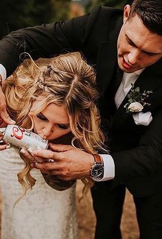 a man helping a woman put on her wedding dress