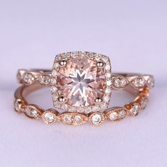 an engagement ring with a pink diamond surrounded by white and rose gold diamonds on the band