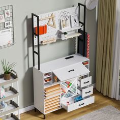 a white desk with lots of drawers and shelves on it in front of a gray wall