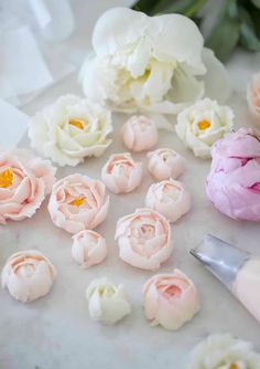 pink and white flowers sitting on top of a table next to a pair of scissors