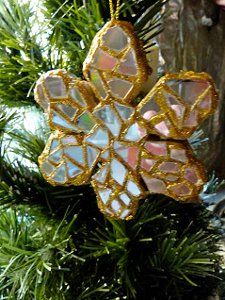 an ornament shaped like a flower hanging from a christmas tree with pine needles