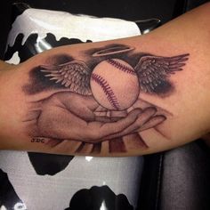 a baseball tattoo on the arm of a person with wings and an angel holding a ball