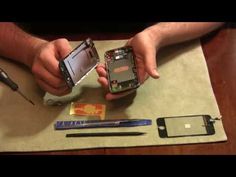 two hands holding cell phones over a table with tools and other items around them on top of a piece of paper