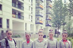 a group of young women standing next to each other in front of a tall building