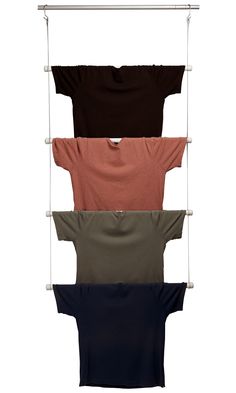 four t - shirts hanging on a clothes rack with three different colors and sizes in them