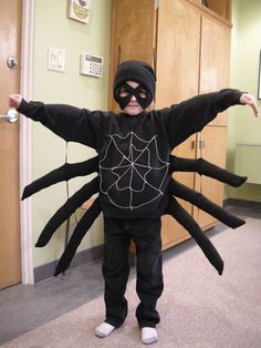 a little boy dressed up in a spider costume