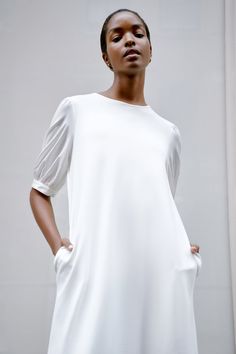 Romanticize your everyday wardrobe with our Olivia Dress. Her body is handcrafted from structured, mid-stretch European ponte with a crew neck and side pockets, while her ruffled hem and puff sleeves in 100% European poplin cotton lend her silhouette a touch of whimsy. From afternoon errands to nights out on the town, this feminine midi transitions effortlessly. With pockets! [SPLIT] Maritza, in black, is 5'9" (177 cm) tall, wearing size XS. Miqueal, in off white, is 5'10" (178 cm) tall, wearing Summer Workwear Dresses With Balloon Sleeves, Summer Work Dresses With Elastic Sleeves, Summer Workwear Dress With Elastic Sleeves, White Dress With Cuffed Sleeves For Work, White Workwear Dresses With Cuffed Sleeves, Elegant Dress With Gathered Sleeves And Relaxed Fit, Workwear Midi Dress With Balloon Pleated Sleeves, Workwear Midi Dress With Pleated Balloon Sleeves, Elegant Crew Neck Dress For Work