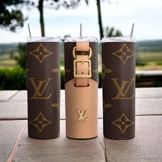 three different types of louis vuitton travel mugs on top of a table