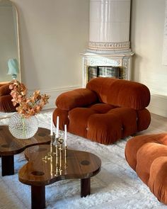 a living room filled with furniture and a fire place in the middle of the room