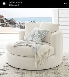 a large white chair sitting on top of a rug