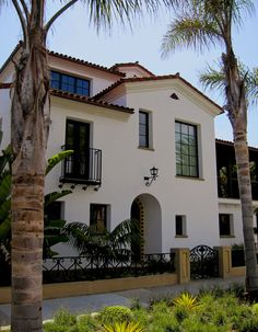 a white house with palm trees in front of it