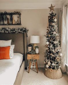 a bedroom decorated for christmas with a small tree and decorations on the bed side table