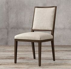 an upholstered dining chair with a white fabric seat and back cushion on a wooden floor