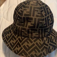 Brand New Designer Brown Hat With Short Brim, Designer Brown Brimmed Hat, Designer Brown Hats For Spring, Designer Brown Hat For Spring, Designer Black Hats For Spring, Designer Black Spring Hats, Designer Black Bucket Hat, Designer Black Summer Hats, Trendy Brown Bucket Hat With Flat Brim