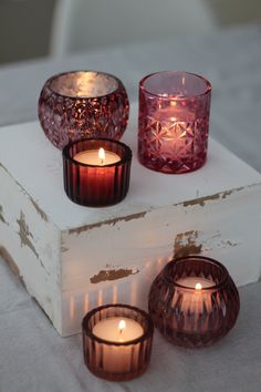 three candles sitting on top of a white box