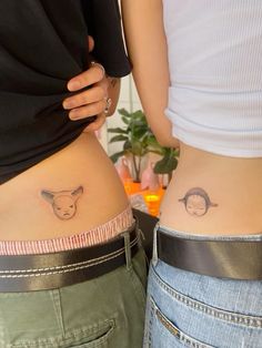 two people with tattoos on their stomachs