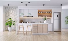 an open concept kitchen and living room with wood flooring, white walls and cabinets