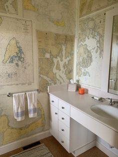 a bathroom with a map on the wall next to a white sink and counter top