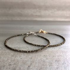 This natural gemstone bracelet features tiny Pyrite crystals. The small glittering beads are a neutral metallic hue. This is a unique, but versatile piece that is perfect alone or layered. These crystals are teeny tiny, about 2 mm each. If you love the look of delicate, dainty jewelry, this bracelet is perfect for you. At checkout, choose a sterling silver or 14K gold filled clasp for your bracelet. * METAPHYSICAL PROPERITIES OF PYRITE * confidence creativity grounding motivation prosperity vita Minimalist Faceted Beads Rondelle Bracelets, Minimalist Bracelets With Faceted Rondelle Beads, Minimalist Rondelle Bracelets With Faceted Beads, Minimalist Round Bracelet With Faceted Beads, Faceted Round Bead Bracelets For Gift, Faceted Round Beads Bracelet For Gift, Faceted Bracelet Gift, Tiny Bead Bracelet, Pyrite Bracelet