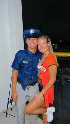 a man and woman dressed in police uniforms posing for the camera with their arms around each other