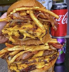 a stack of cheeseburger with fries and soda