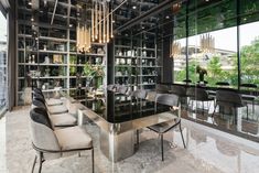 an elegant dining room with glass walls and chandelier