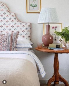 a bedroom with a bed, lamp and pictures on the wall next to each other