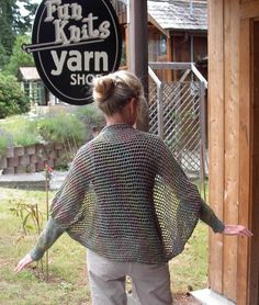 a woman standing in front of a sign that says fink knits yarn shop