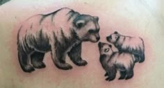 a bear and two cubs tattoo on the back of a man's left shoulder