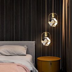 three lights hanging from the ceiling above a bed in a room with black wallpaper