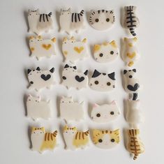 a group of ceramic cats sitting next to each other on top of a white table