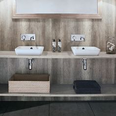 two white sinks sitting on top of a wooden shelf