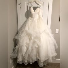 a wedding dress hanging on a door