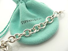 Offered for sale is a wonderful and super cute Tiffany and Co. Sterling Silver 1837 Cube / Box Charm bracelet. The piece is made from substantial and bright Tiffany silver, and yet retains a very feminine feel to it. Attached to its very substantial and bright Tiffany Silver charm bracelet is a super Cool 1837 Cube Padlock charm. The Gift Box padlock charm is permanently attached to the bracelet - so you will not ever have the risk of losing the charm! It is a classic Tiffany piece that will mos Luxury Sterling Silver Jubilee Bracelet As Gift, Luxury Silver Jewelry With Original Box, Luxury Sterling Silver Bracelet With Polished Finish For Gifts, Elegant Sterling Silver Bracelet With Box Clasp As Gift, Designer Silver Jewelry With Original Box, Designer Silver Jewelry In Original Box, Designer Rectangular Bracelets As Gift, Luxury Rectangular Bracelet Gift, Luxury Rectangular Bracelet As Gift