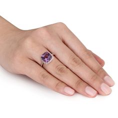 Classic and elegant, this exquisite gemstone fashion ring makes a thoughtful gift for the February birthday girl. Created in 10K rose gold, this ring showcases an impressive 10.0mm cushion-cut bright purple amethyst center stone. A halo frame of shimmering diamonds surrounds the center stone and lines the ring's slim shank. A thoughtful look she'll turn to often, this ring captivates with 1/10 ct. t.w. of diamonds and a bright polished shine. Elegant Purple Diamond Birthstone Ring, Elegant Purple Birthstone Ring For Formal Occasions, Elegant Formal Purple Birthstone Ring, Elegant Rose Gold Birthstone Ring With Gemstone, Purple Diamond Ring Fine Jewelry, Formal Rose Gold Birthstone Ring With Accent Stones, Elegant Rose Gold Amethyst Ring With Birthstone, Cushion Cut Rings With Accent Stones, Purple Diamond Ring In Fine Jewelry Style